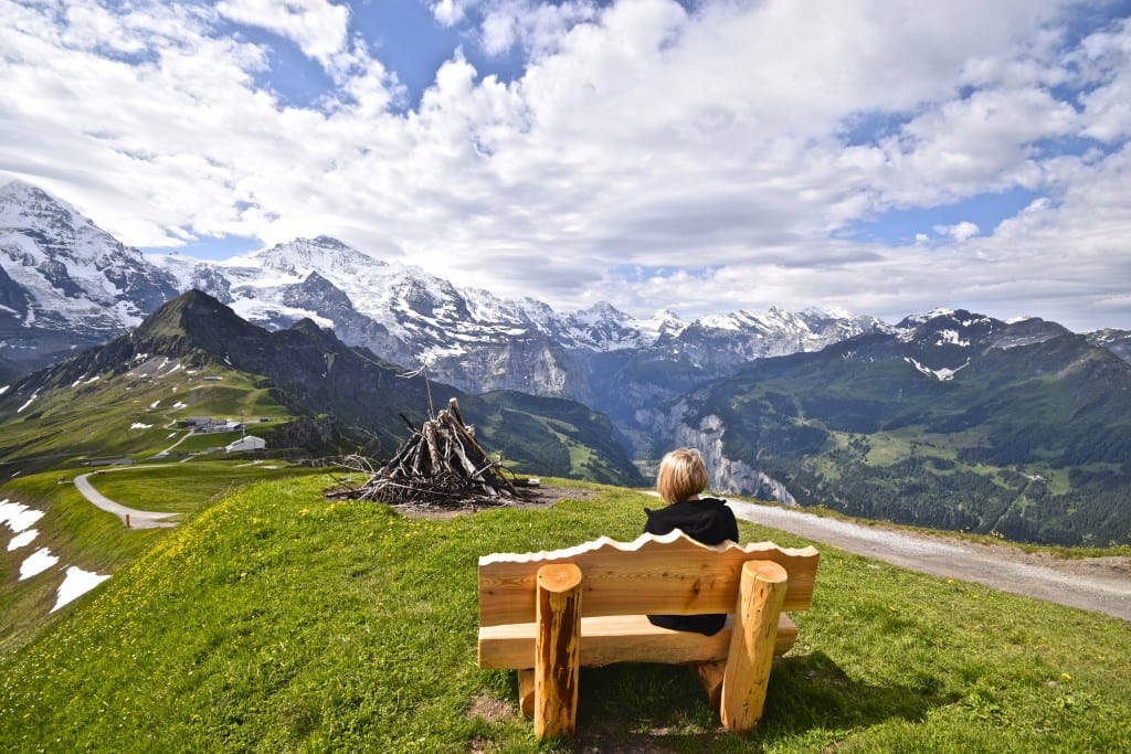 A wooden bench sitting in front of a mountain