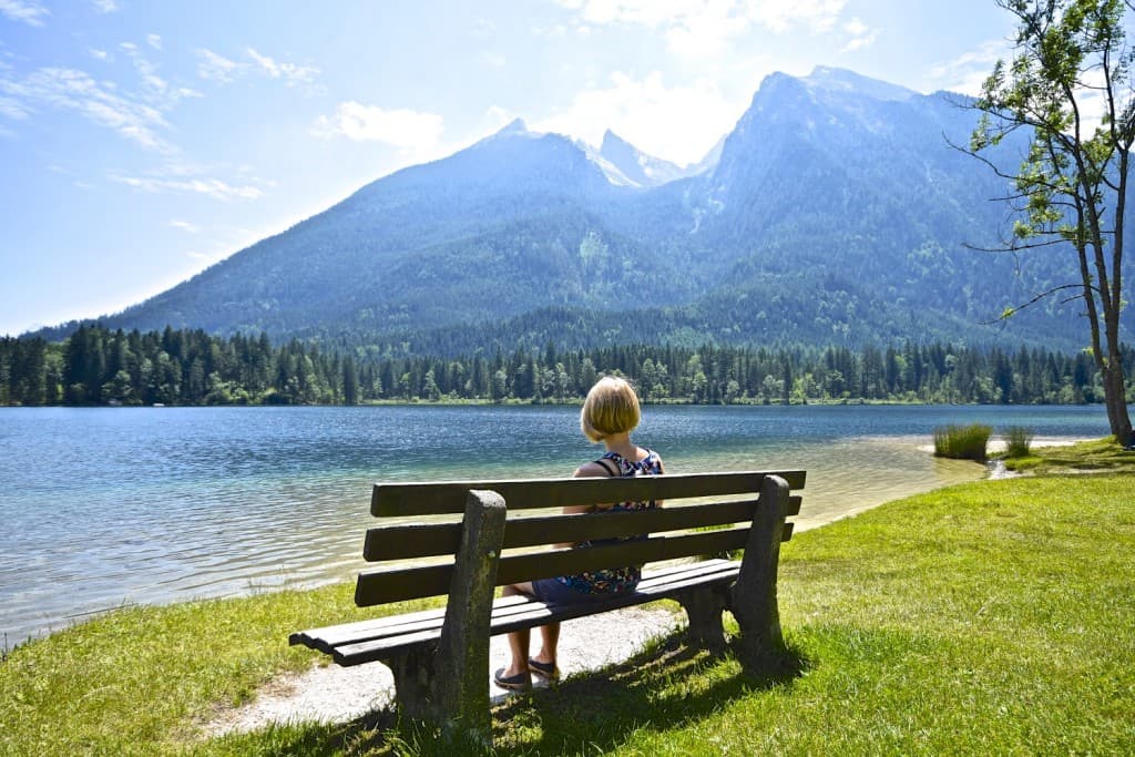 A person sitting on a bench in front of a body of water