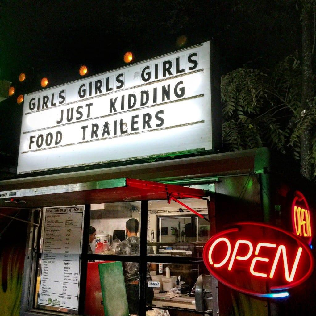 A sign above a store front at night