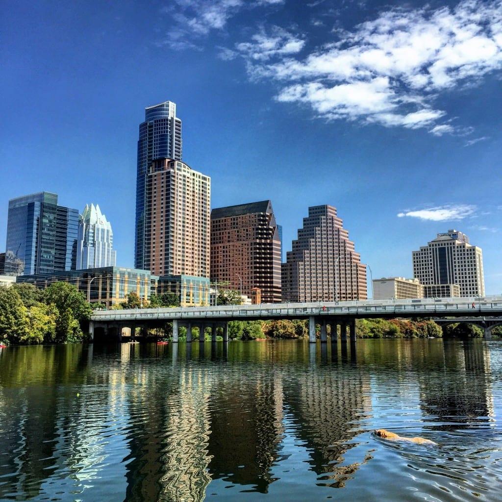 A bridge over a body of water with a city in the background