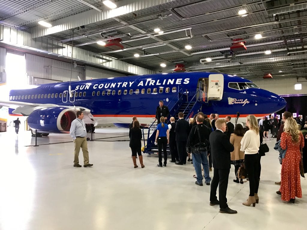 A group of people standing around a plane