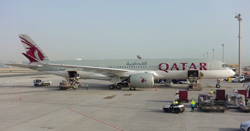 A Qatar airplane that is parked on the tarmac at an airport