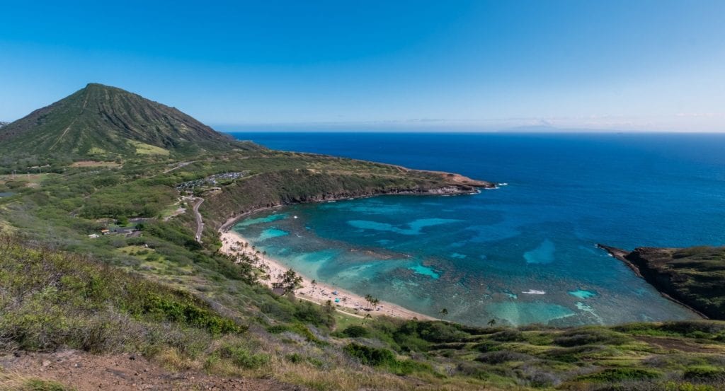 A body of water with a mountain in the ocean