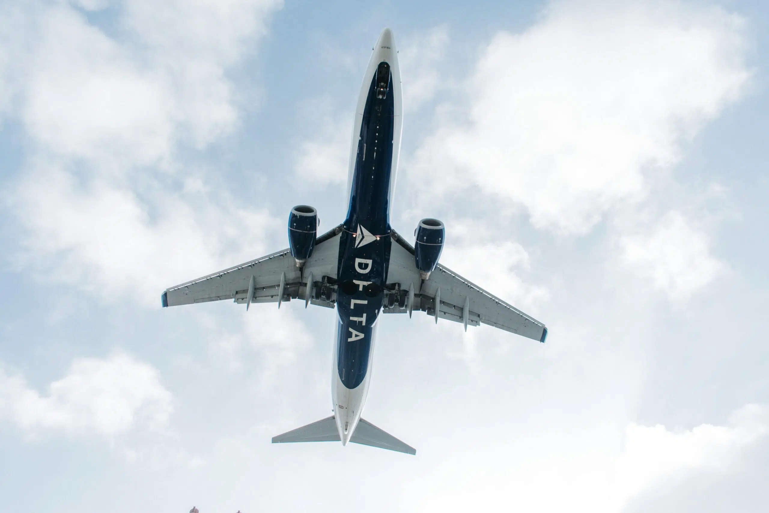 a delta airplane flying through the sky