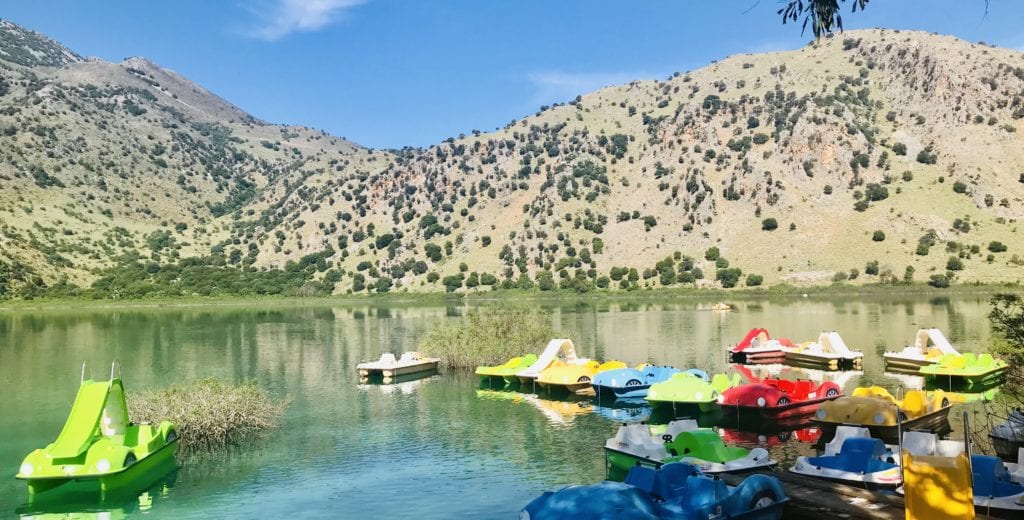 small boats in a body of water with a mountain in the background