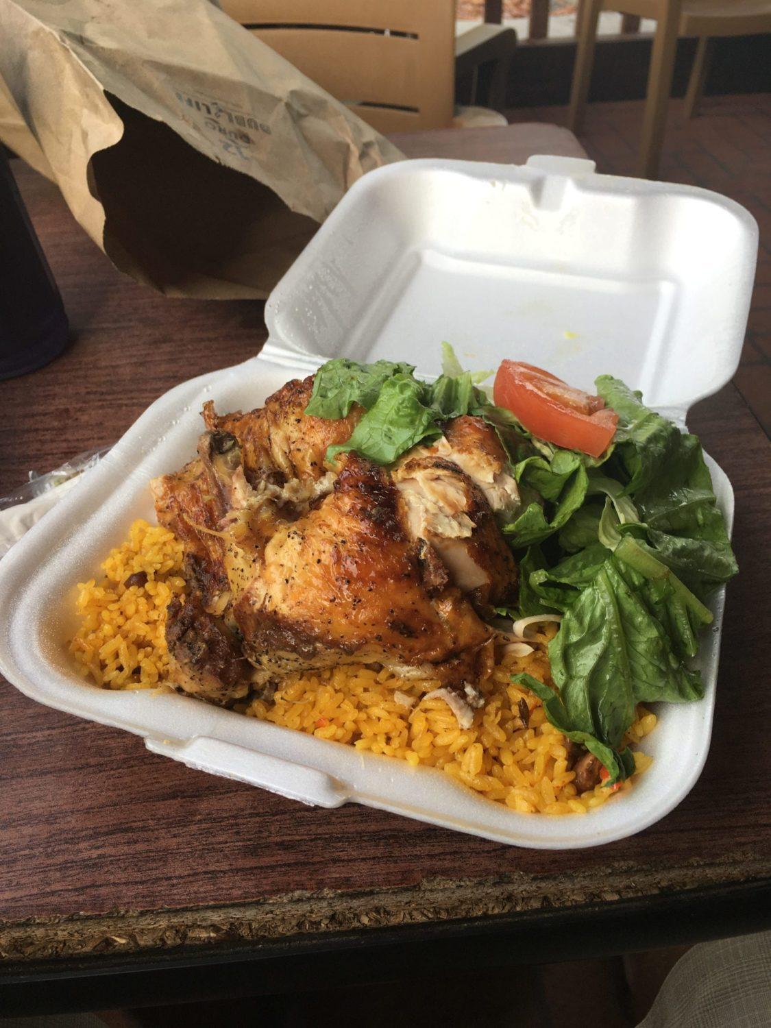 A plate of food on a table, with Rice and Chicken