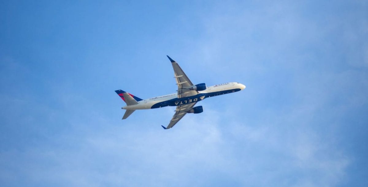 A large passenger jet flying through a cloudy blue sky