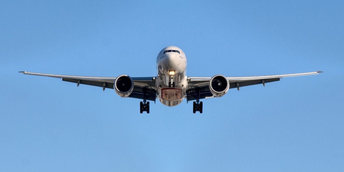 A large passenger jet flying through a blue sky