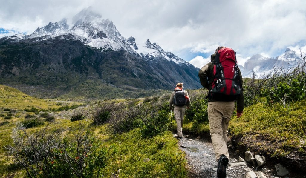 A man and woman standing in front of a mountain