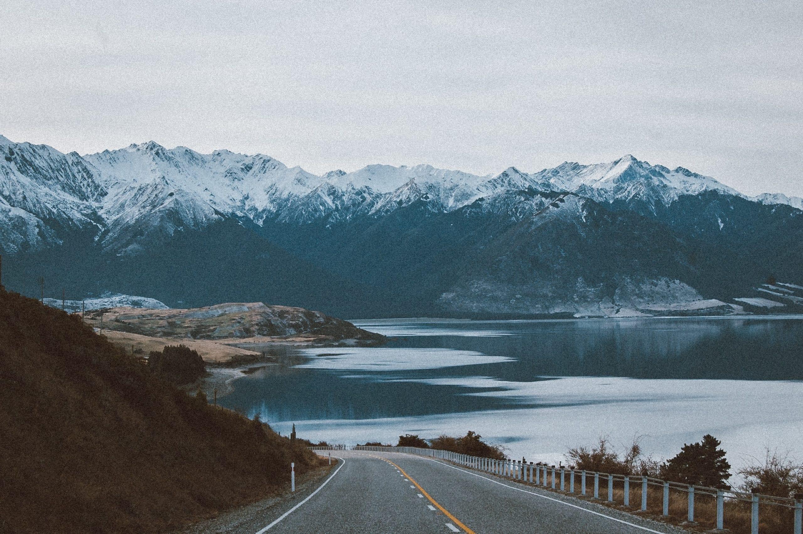 A body of water with a mountain in the snow