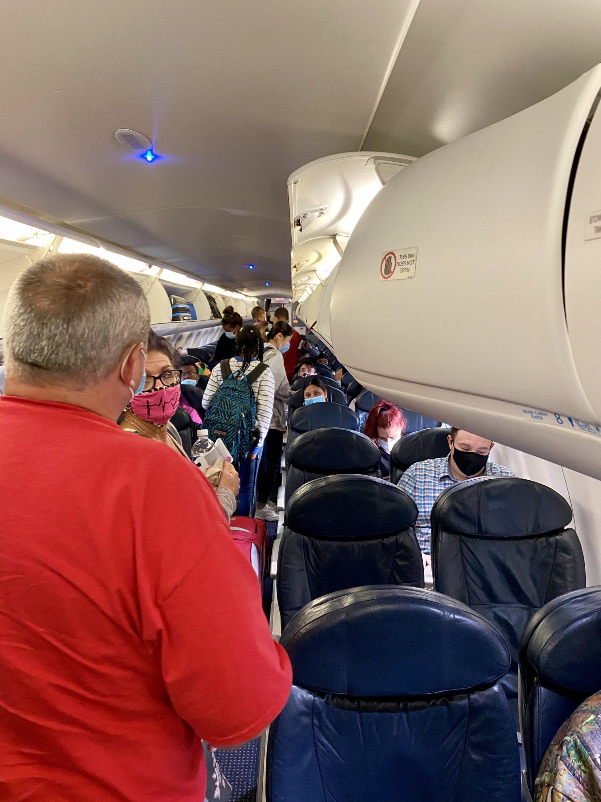 A group of people standing in an airplane 