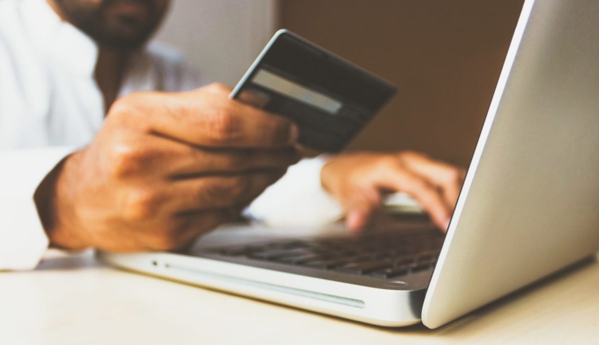 person holding credit card at computer