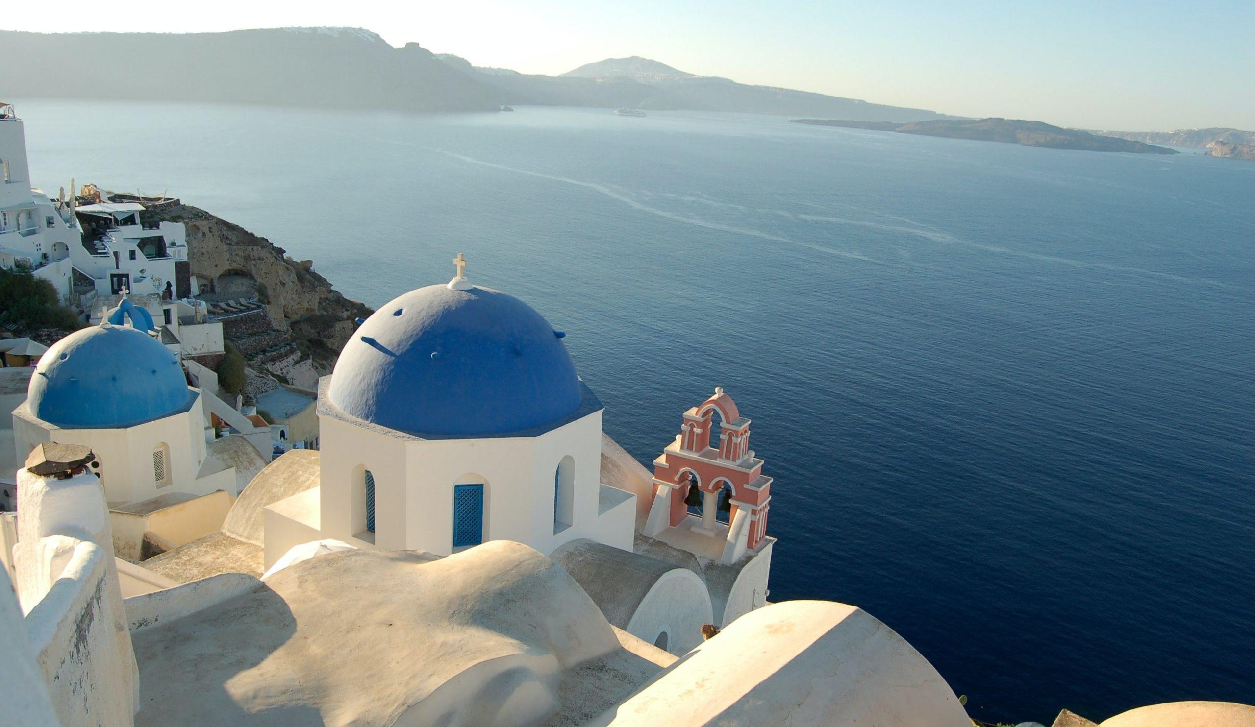 A large body of water with Santorini in the background