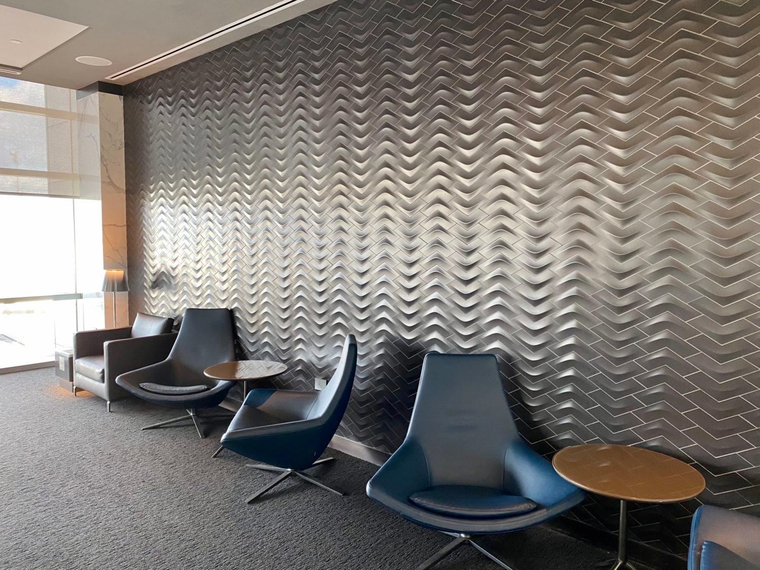 black armchairs in front of a silver accent wall