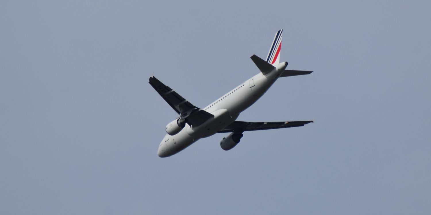 A large passenger jet flying through the air on a cloudy day