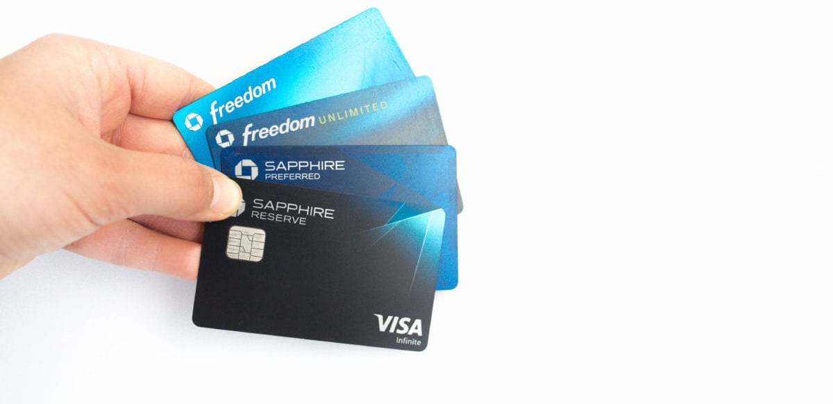 a woman holding four chase credit cards