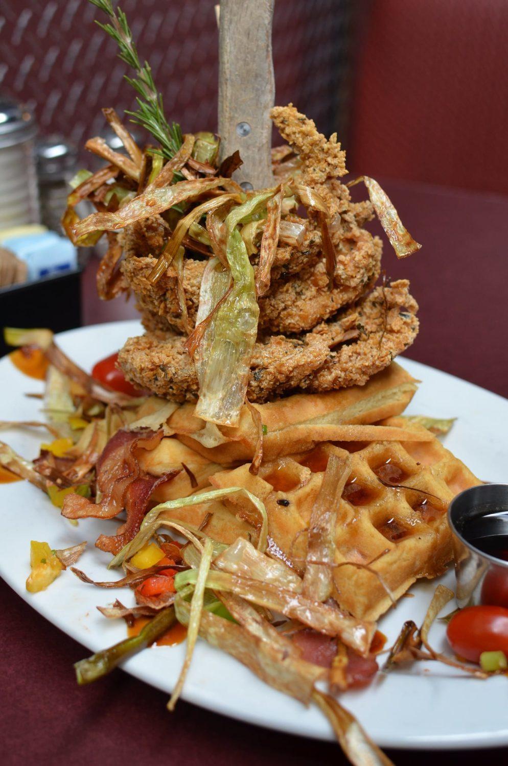 A plate of food with crispy waffles and golden fried chicken