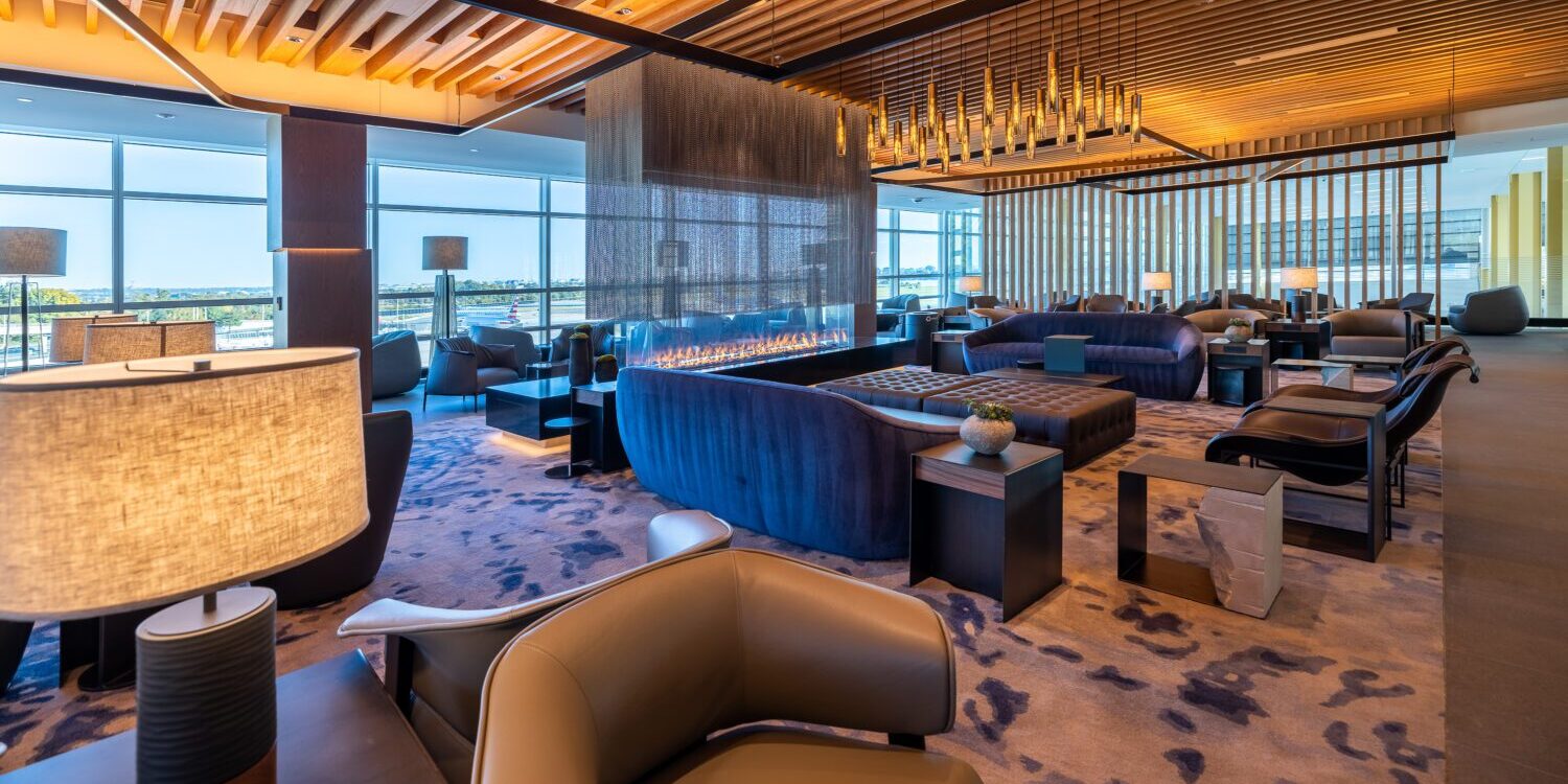 American Goes Premium, Announcing New 'Flagship' Check-In and Massive Lounge in Dallas 2 The American Airlines Admirals Club Lounge at DCA, with a variety of seating options, tables with lamps, and lots of natural light from the floor to ceiling windows.