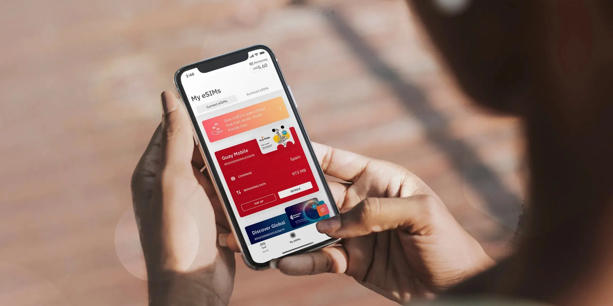 A person holding a cellphone looking at Airalo eSIMs