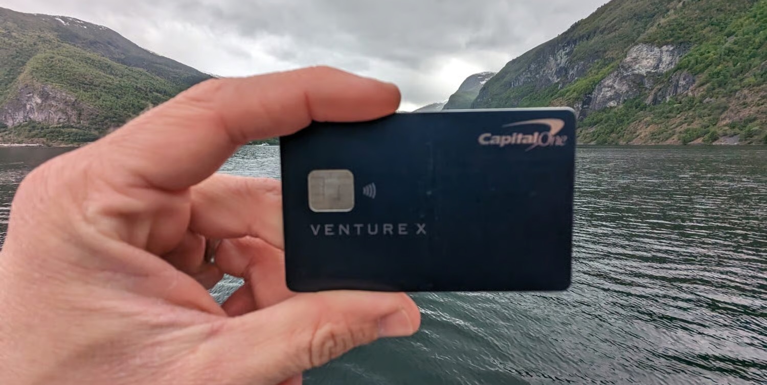 Capital One Venture X Card with Norwegian fjord in the background.