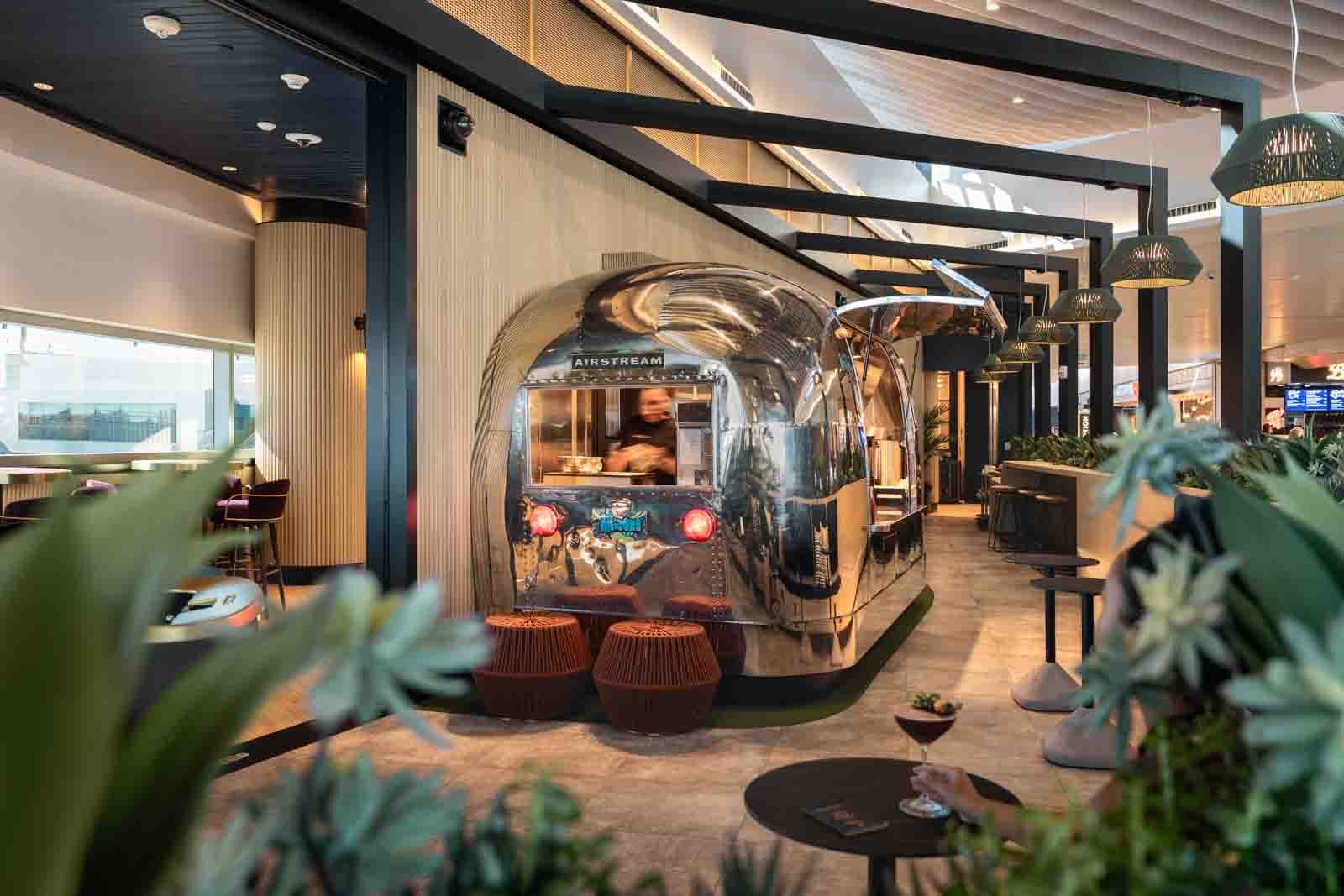 Our Top 10 Most-Read Stories from 2025 1 A airstream trailer with bar seating inside an airport lounge