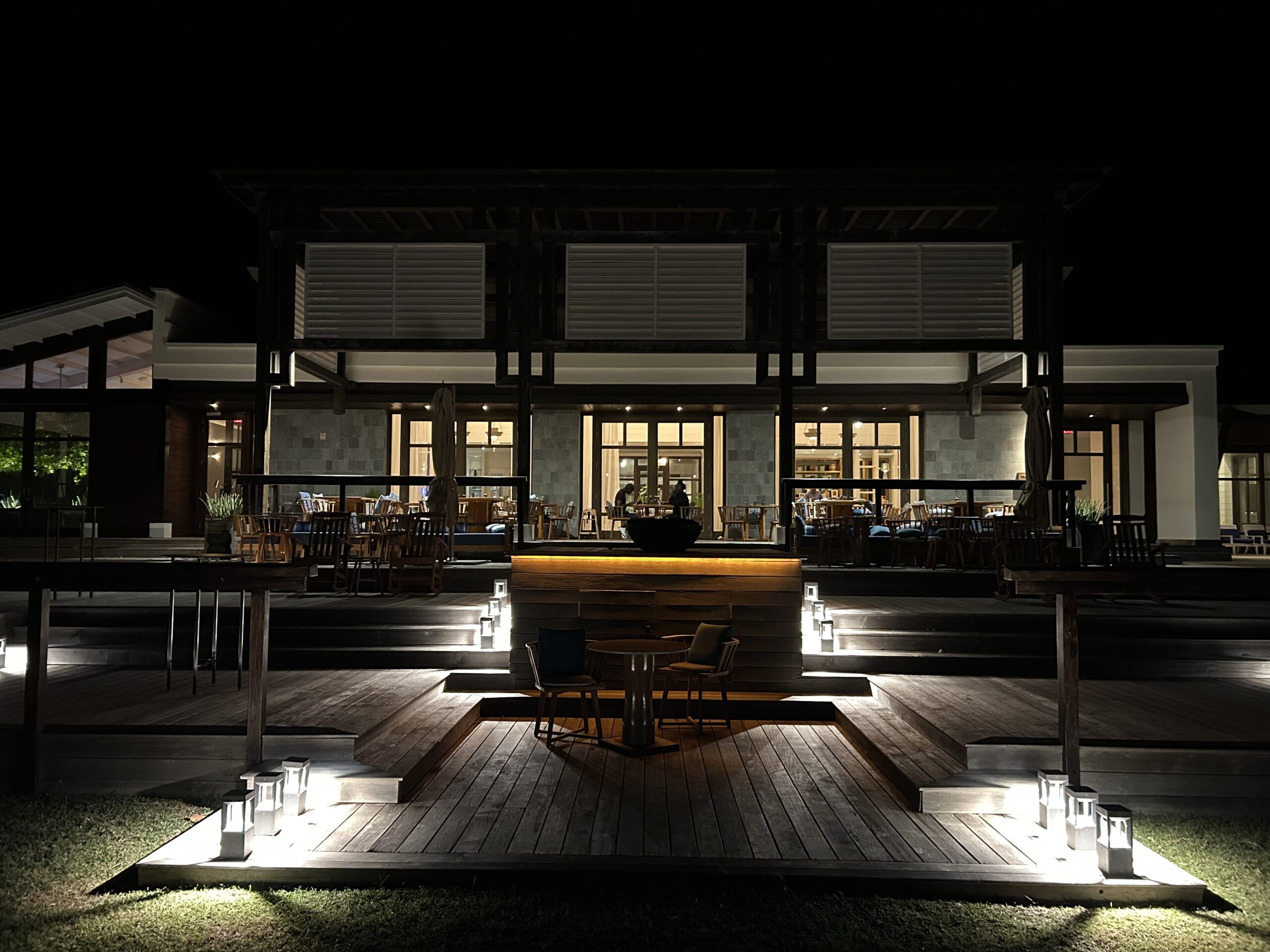 a hotel restaurant at night with a wooden patio and walkways