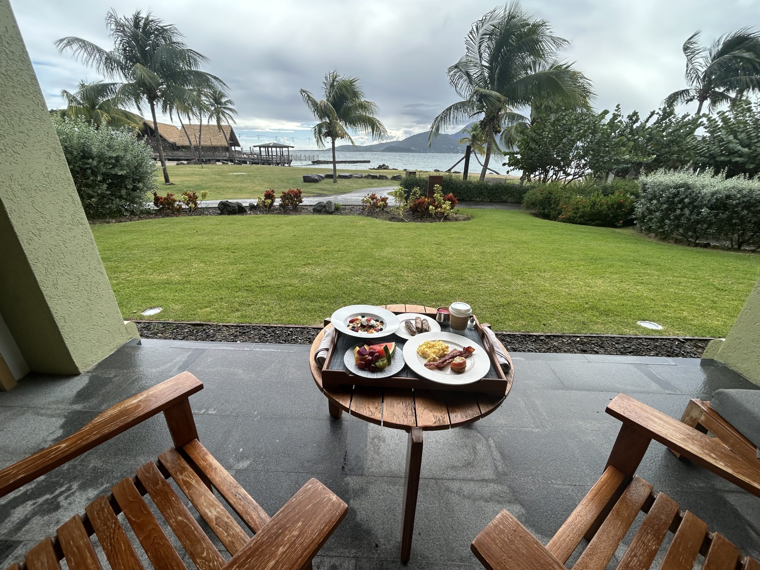 Room service spread on a table overlooking the ocean. 