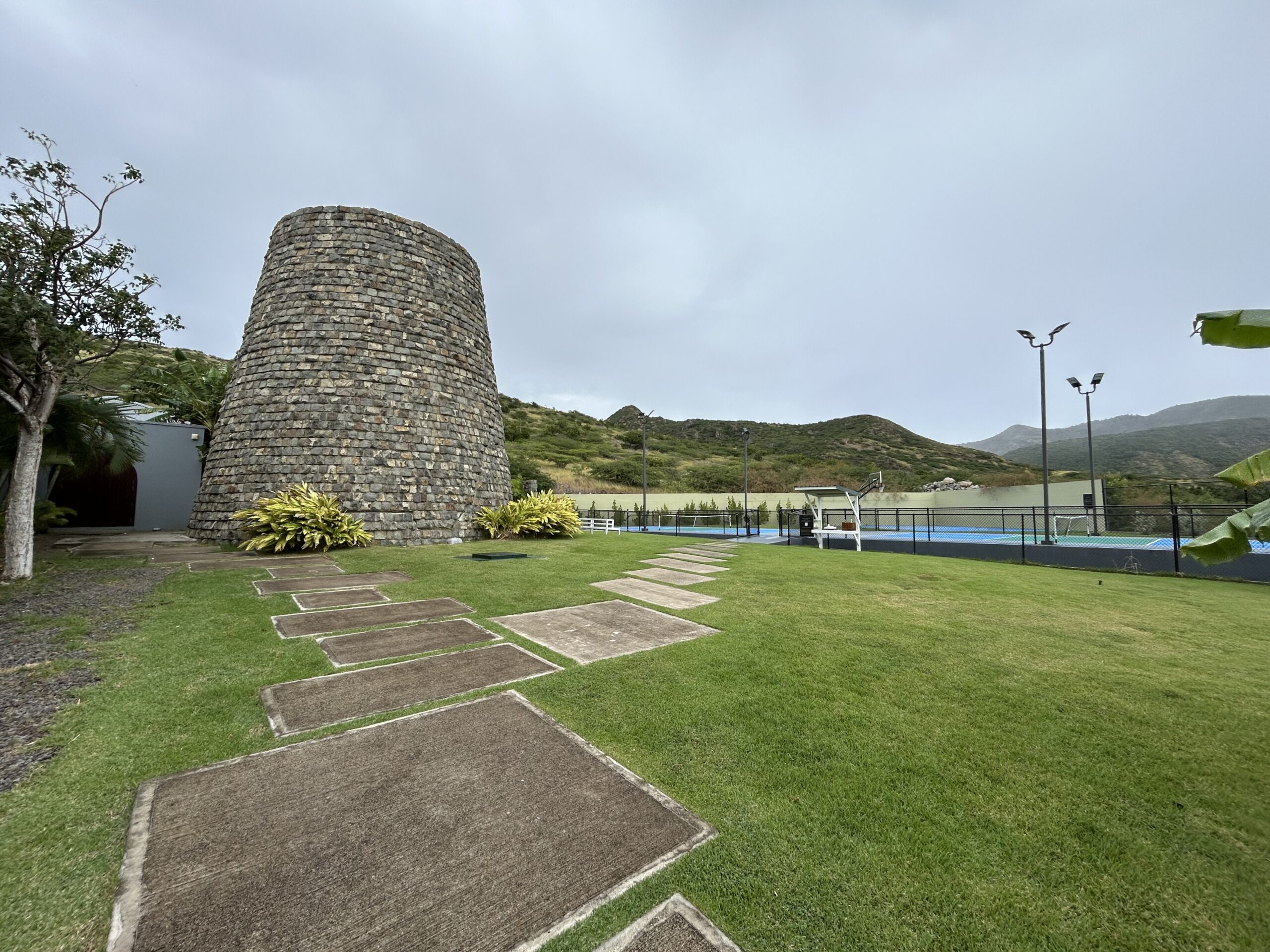 steps leading to the stone mill with pickleball and basketball courts in the background. 