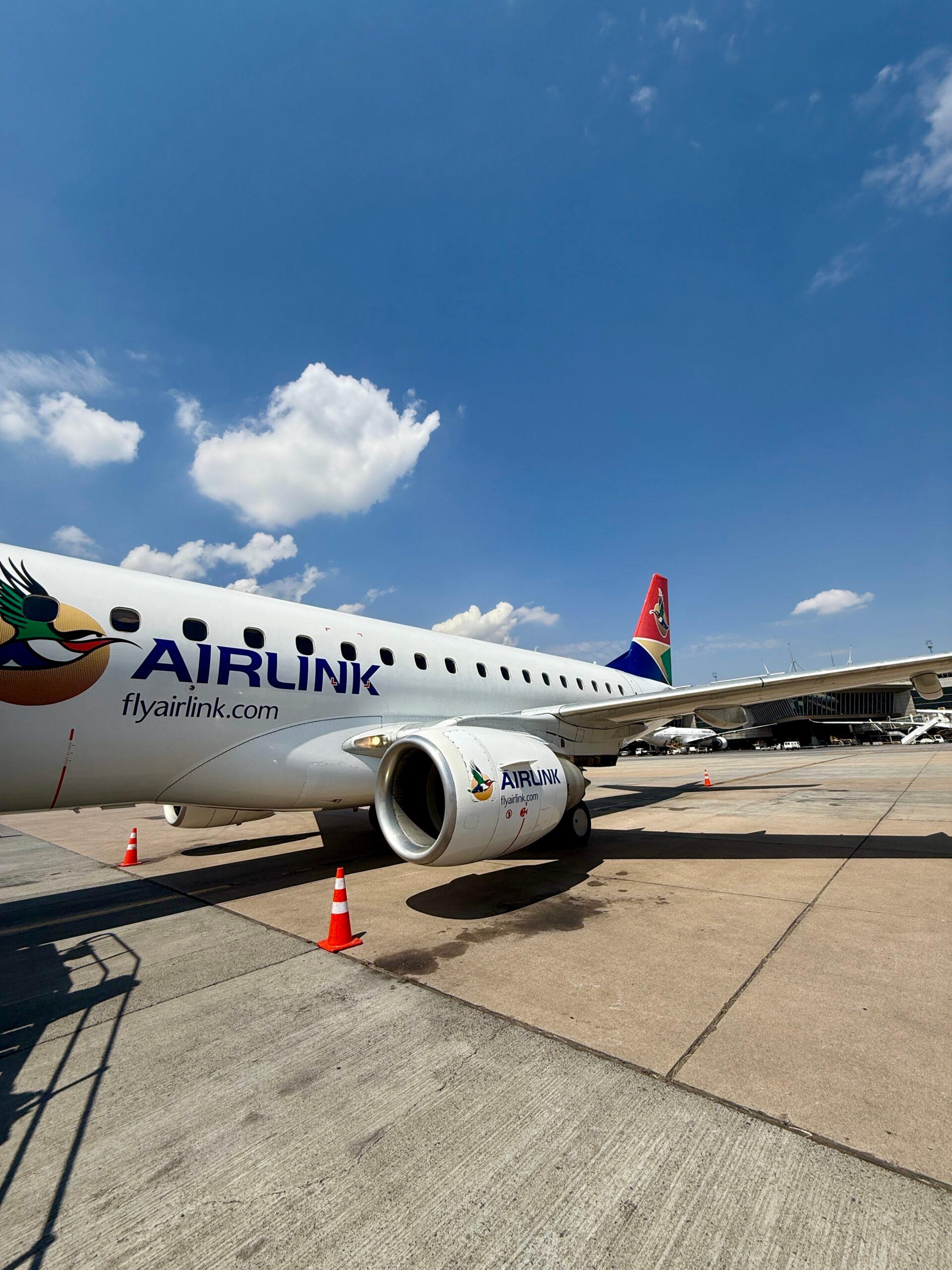 plane on tarmac surrounded by cones and a jetbridge