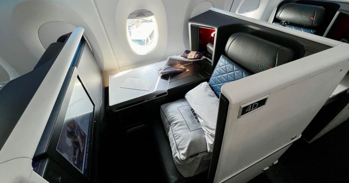 delta one suite with amenities on the seat and a menu on the console