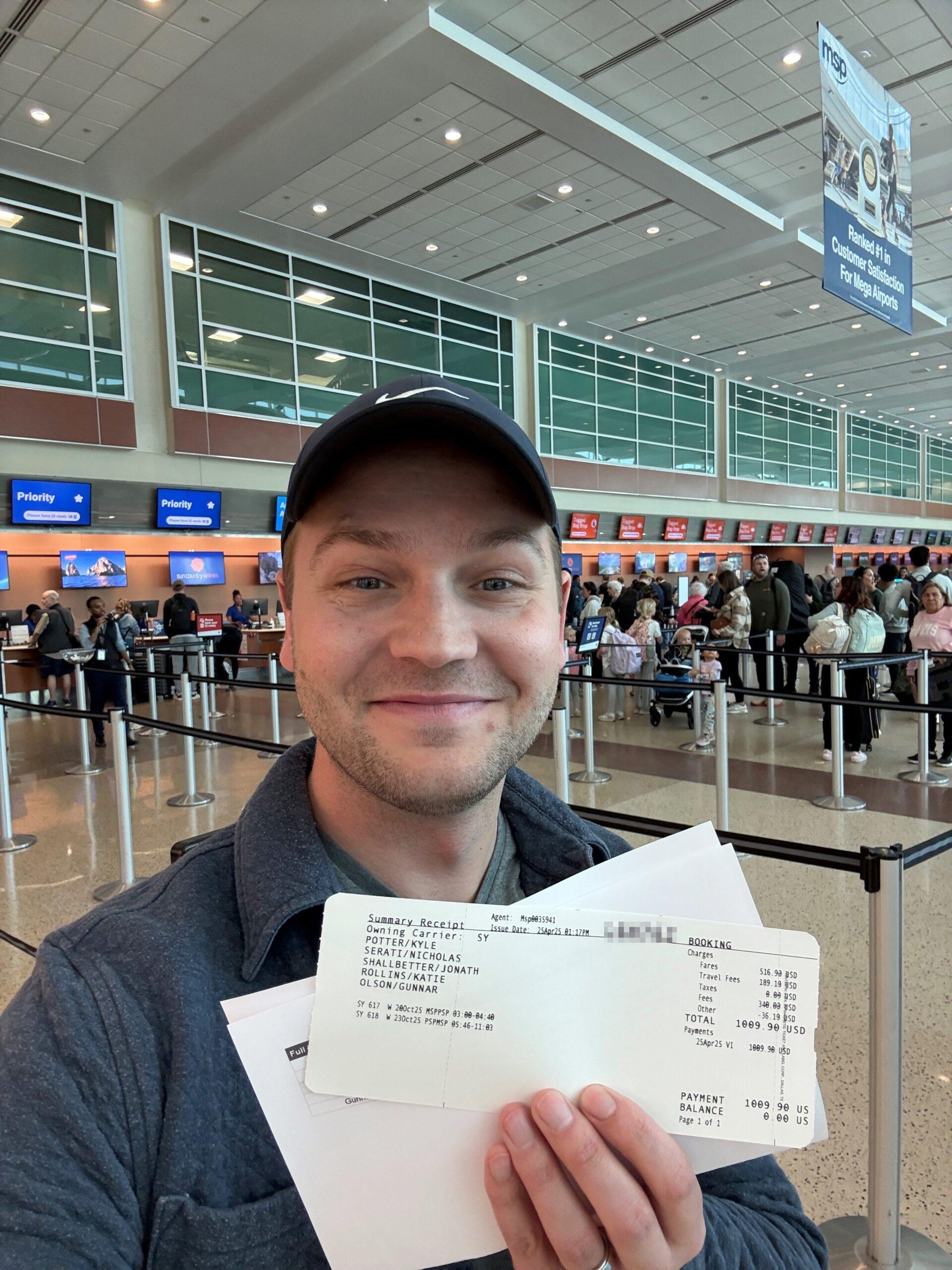 man holding plane tickets at airport