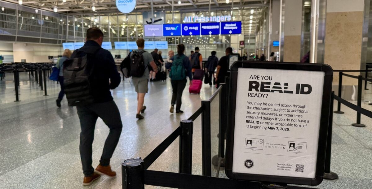 real id signage as passengers walk into security queue at airport