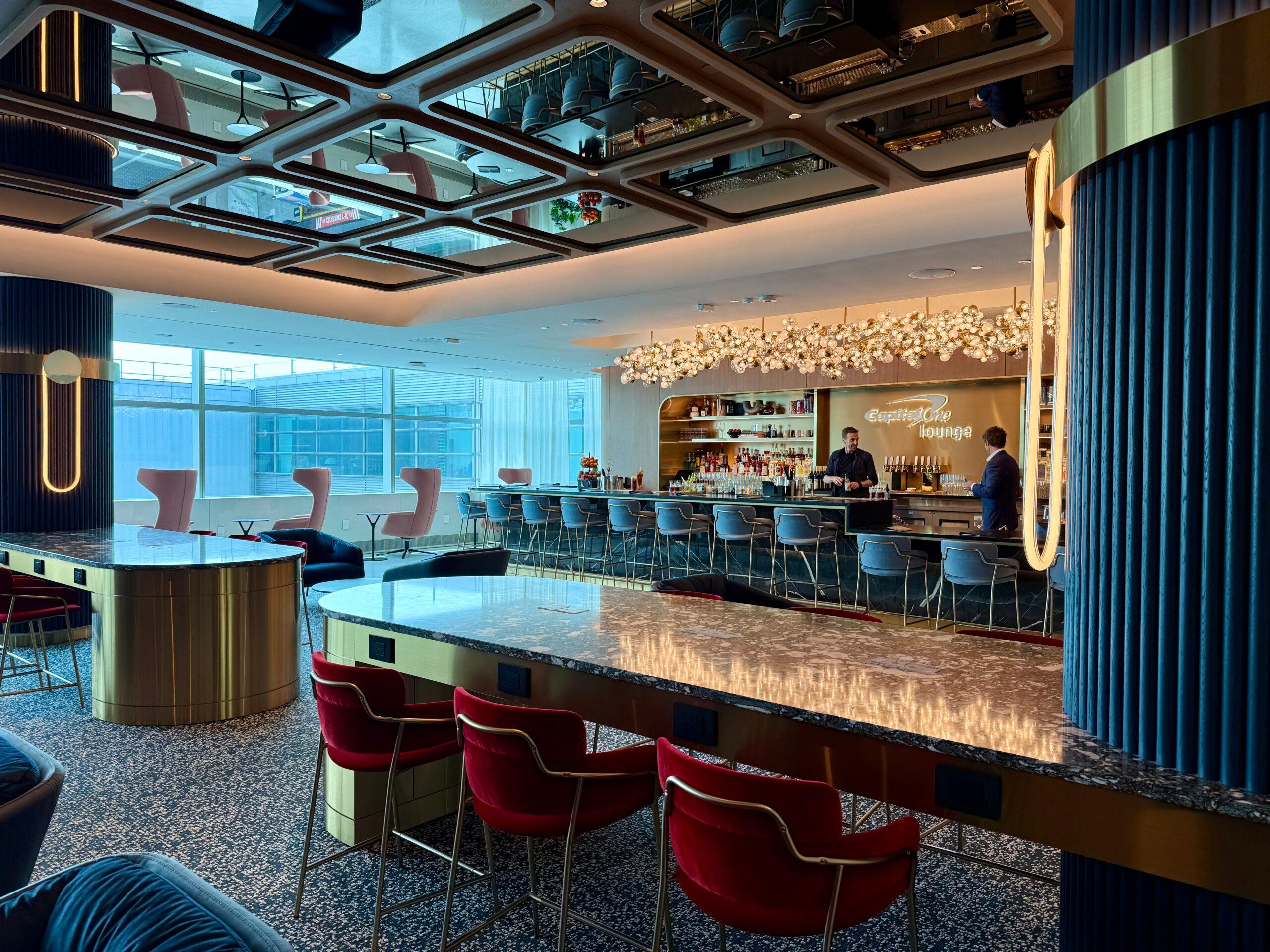 red stools at a long counter with reflective surface overhead