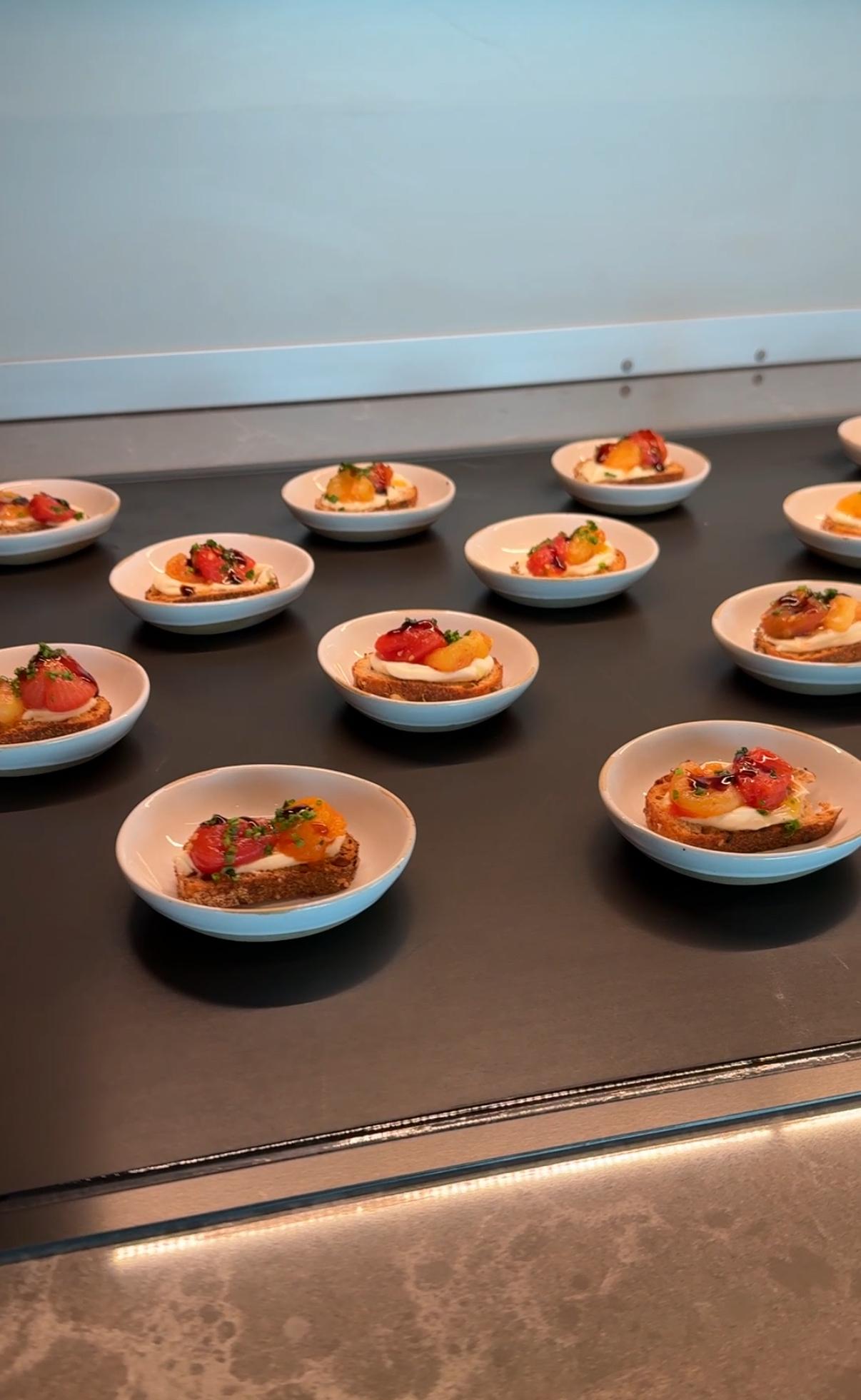 dishes of crostini with tomato on a large black surface