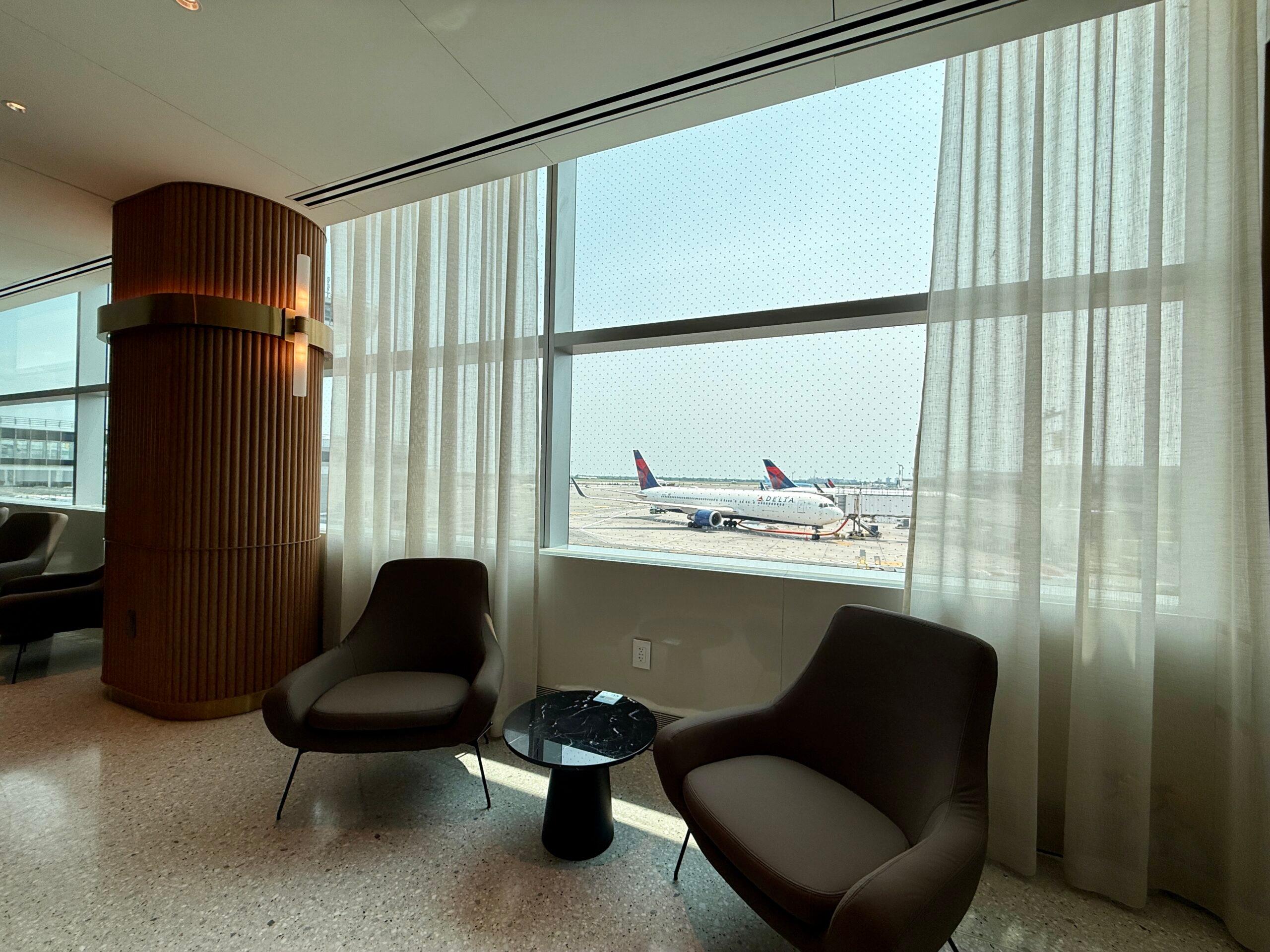 two chairs sitting in front of a window with planes in the background