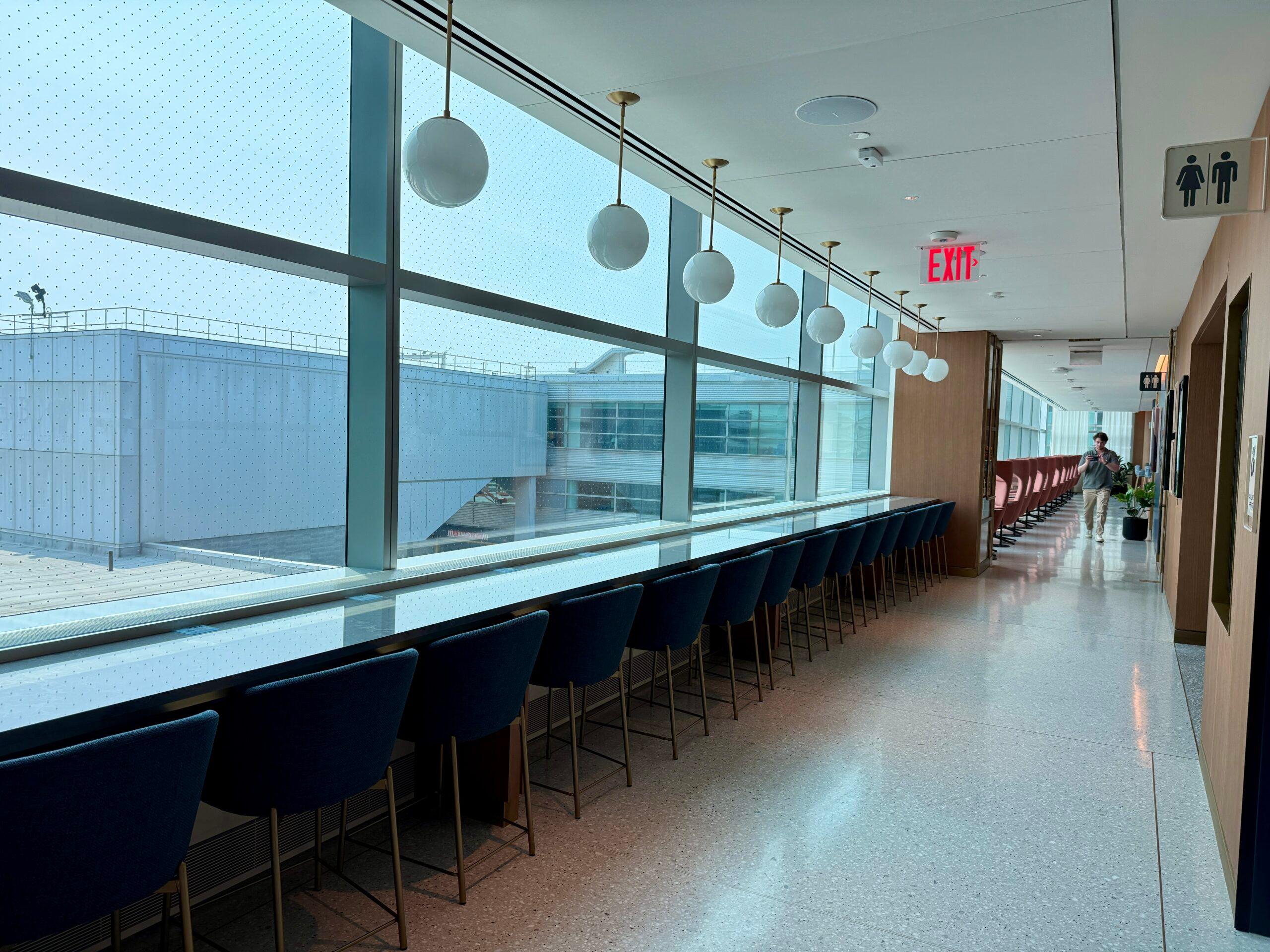 a long counter with stools in front of a window