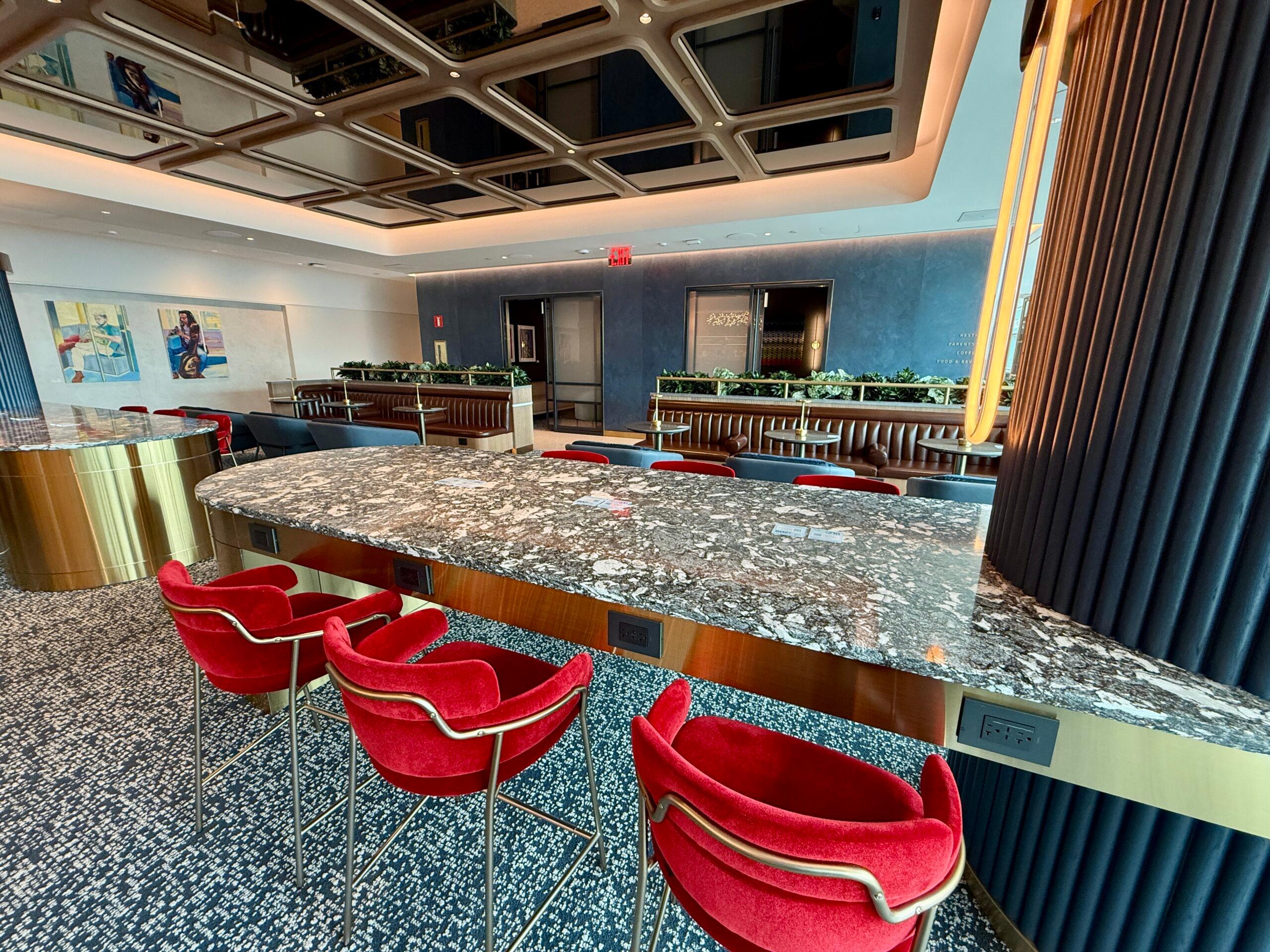 red stools at a black marble counter