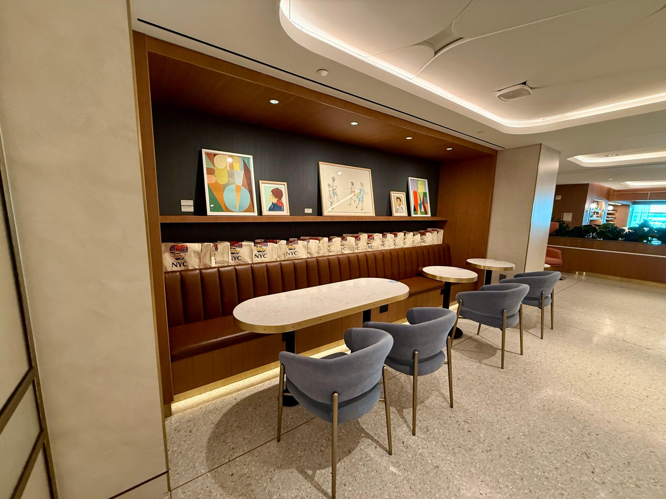chairs and bistro tables in front of a brown leather bench