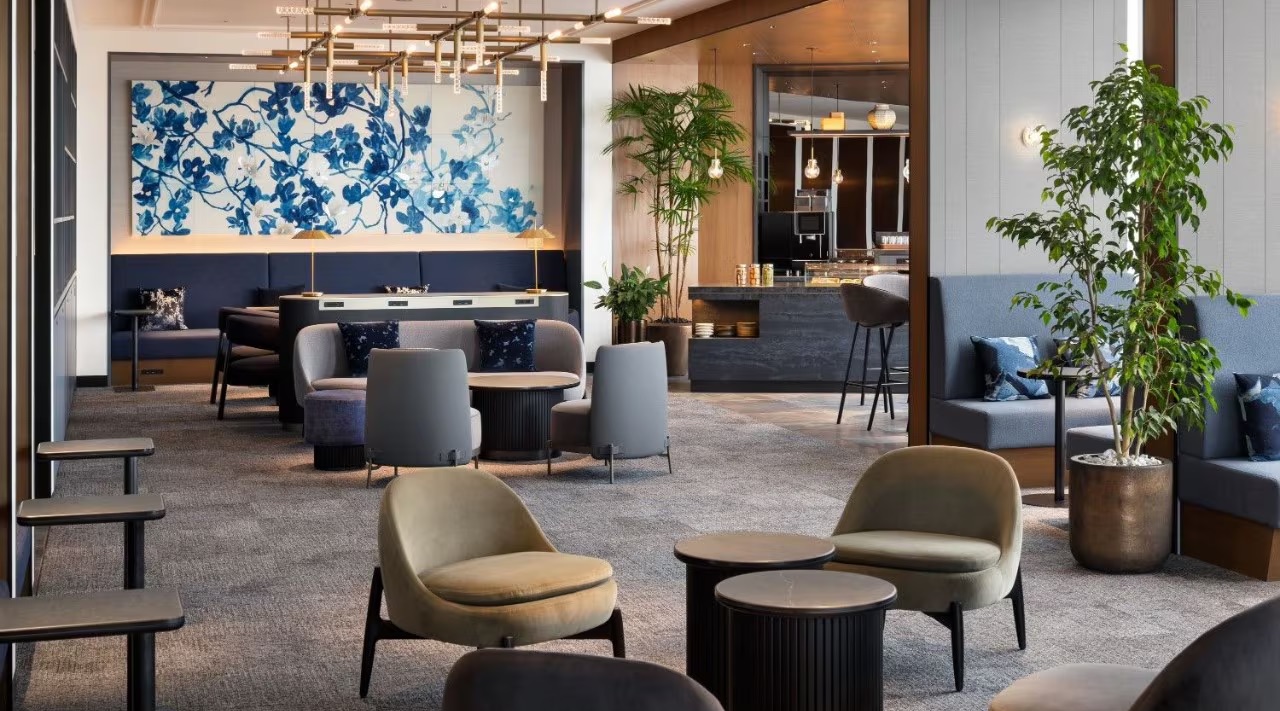 Centurion Lounge (HND) Seating Area with several different low-back chairs and a bigger table and booth seating in the back. 