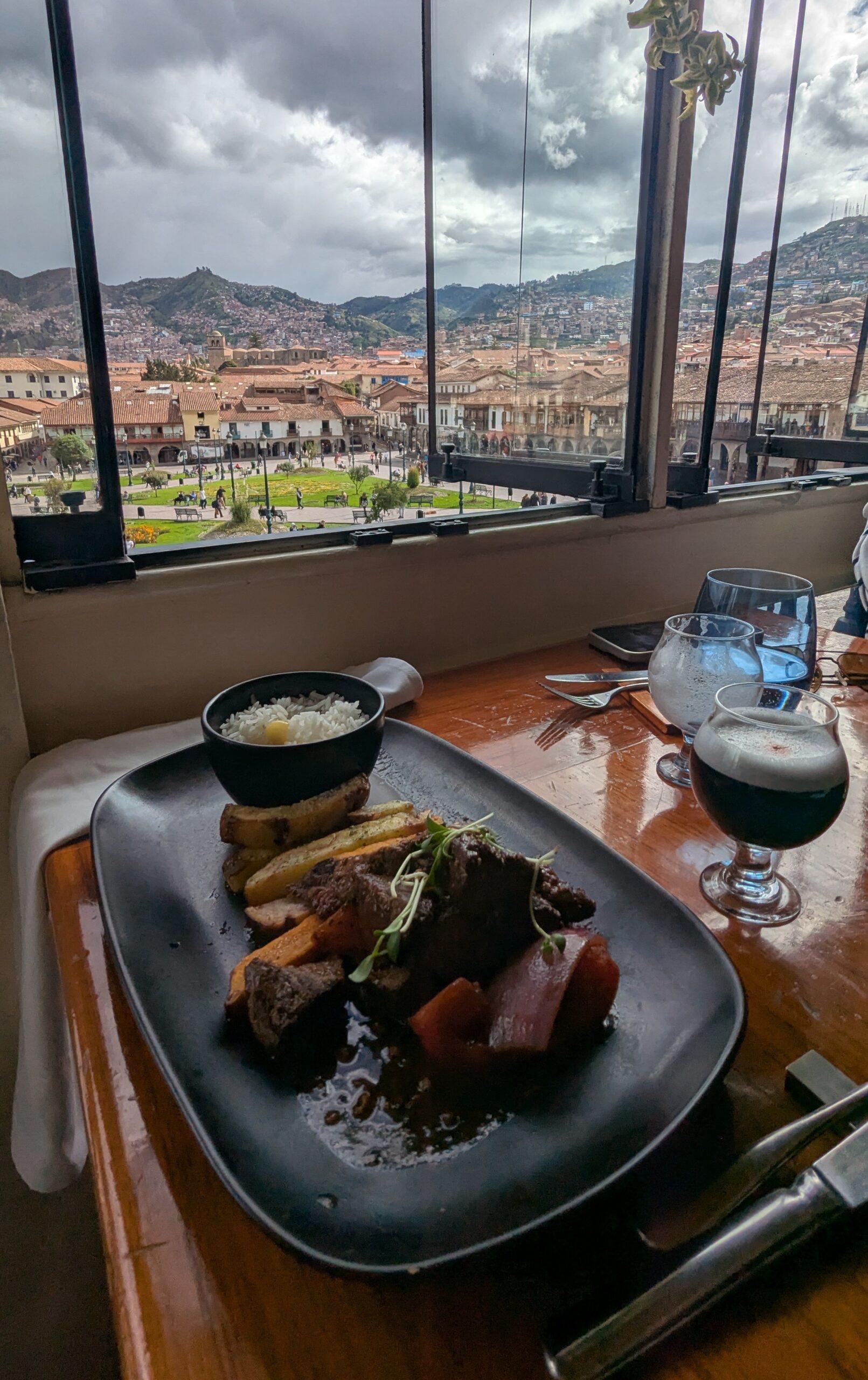 Lomo saltado and black pisco sour at Hanz Gastronomique in Cusco Peru, overlooking the Andes Mountains.
