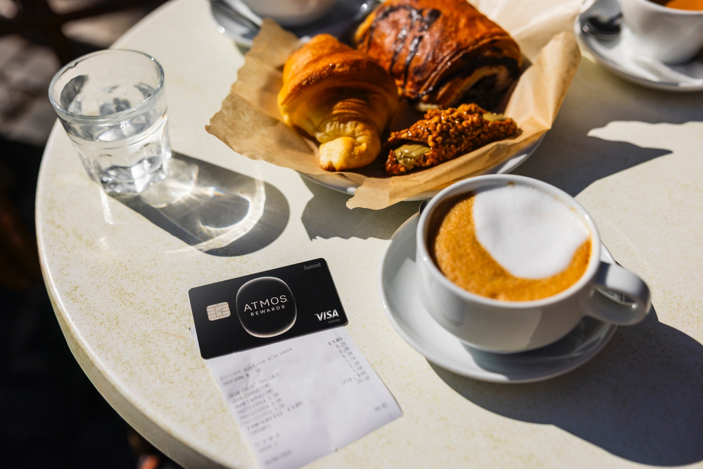 atmos rewards card on a table with coffee and croissant