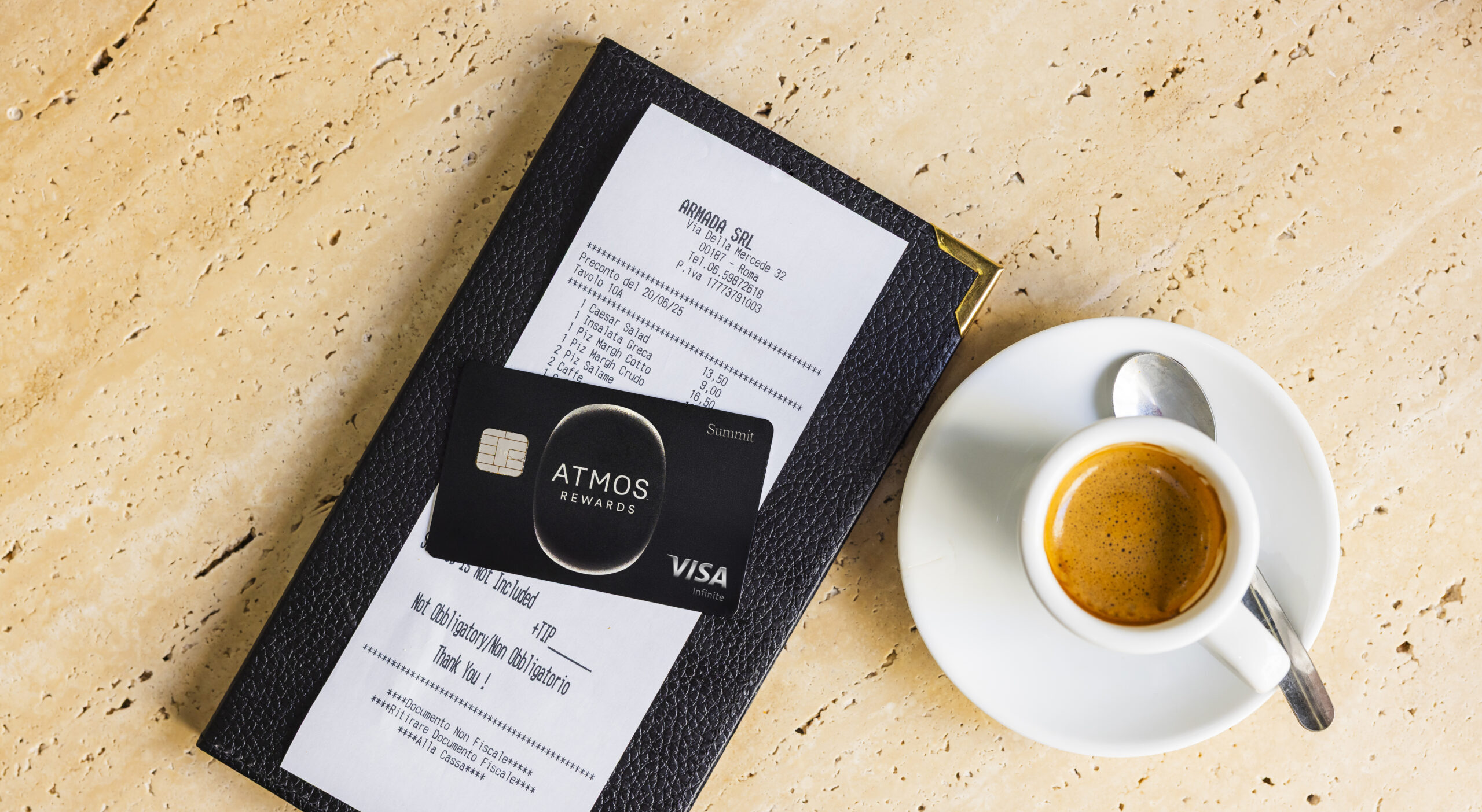 atmos rewards summit visa card on top of a bill with a shot of espresso