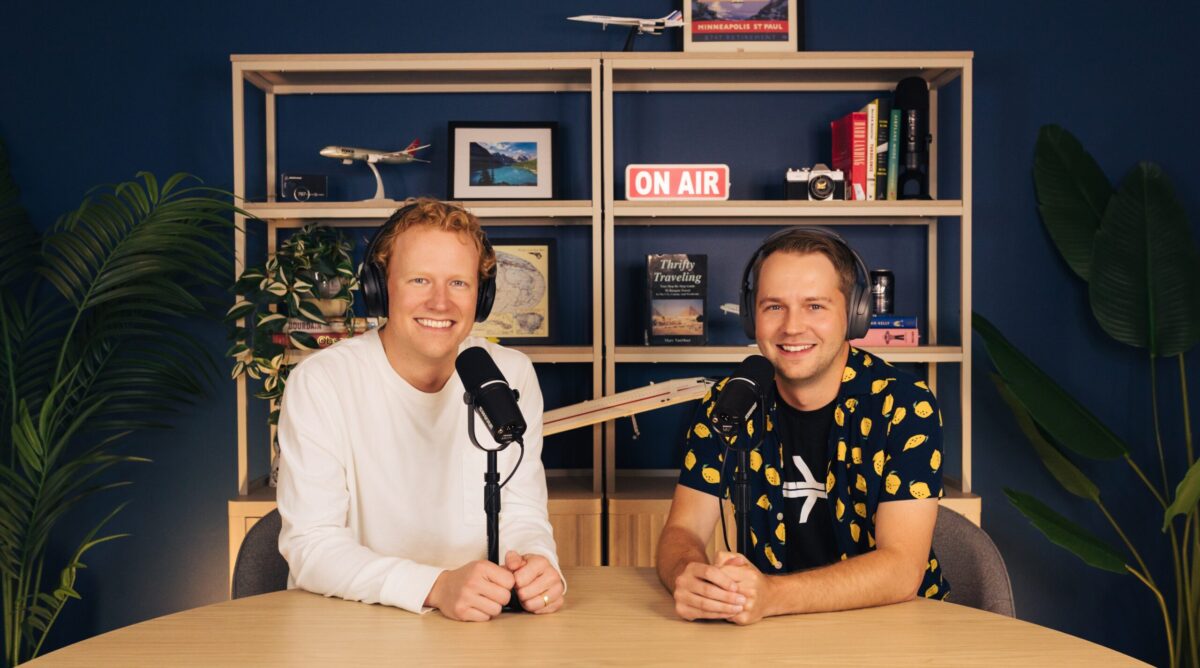 Thrifty Traveler Podcast hosts pose for a photo in their studio.