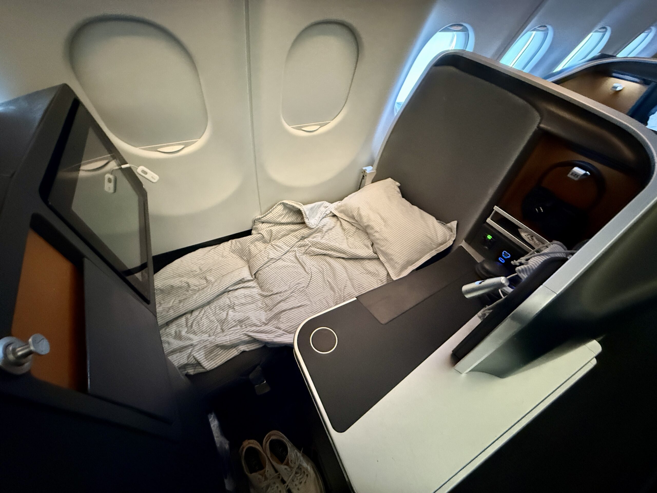 lie-flat business class seat covered in bedding