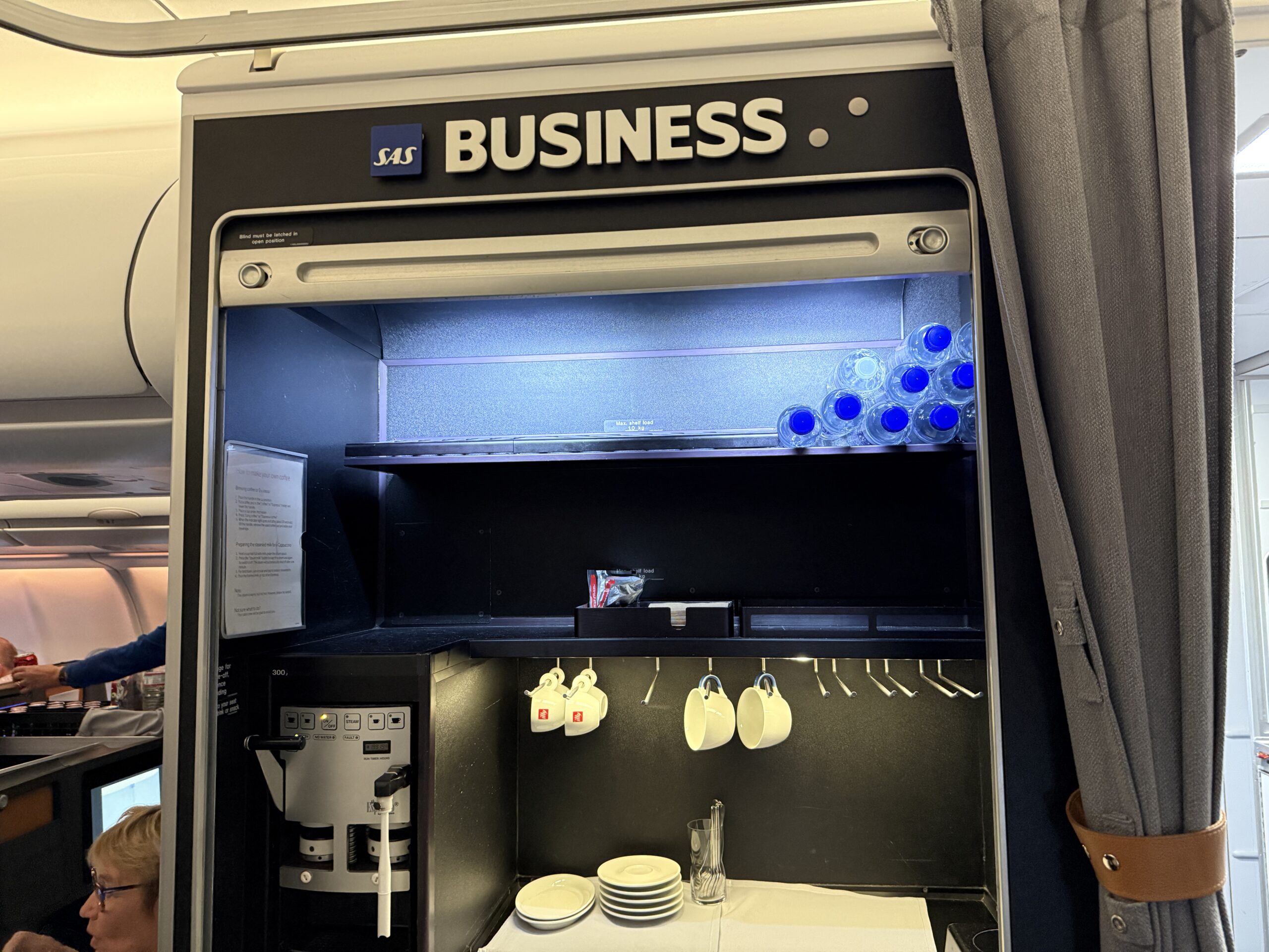 coffee bar on a plane with cups hanging