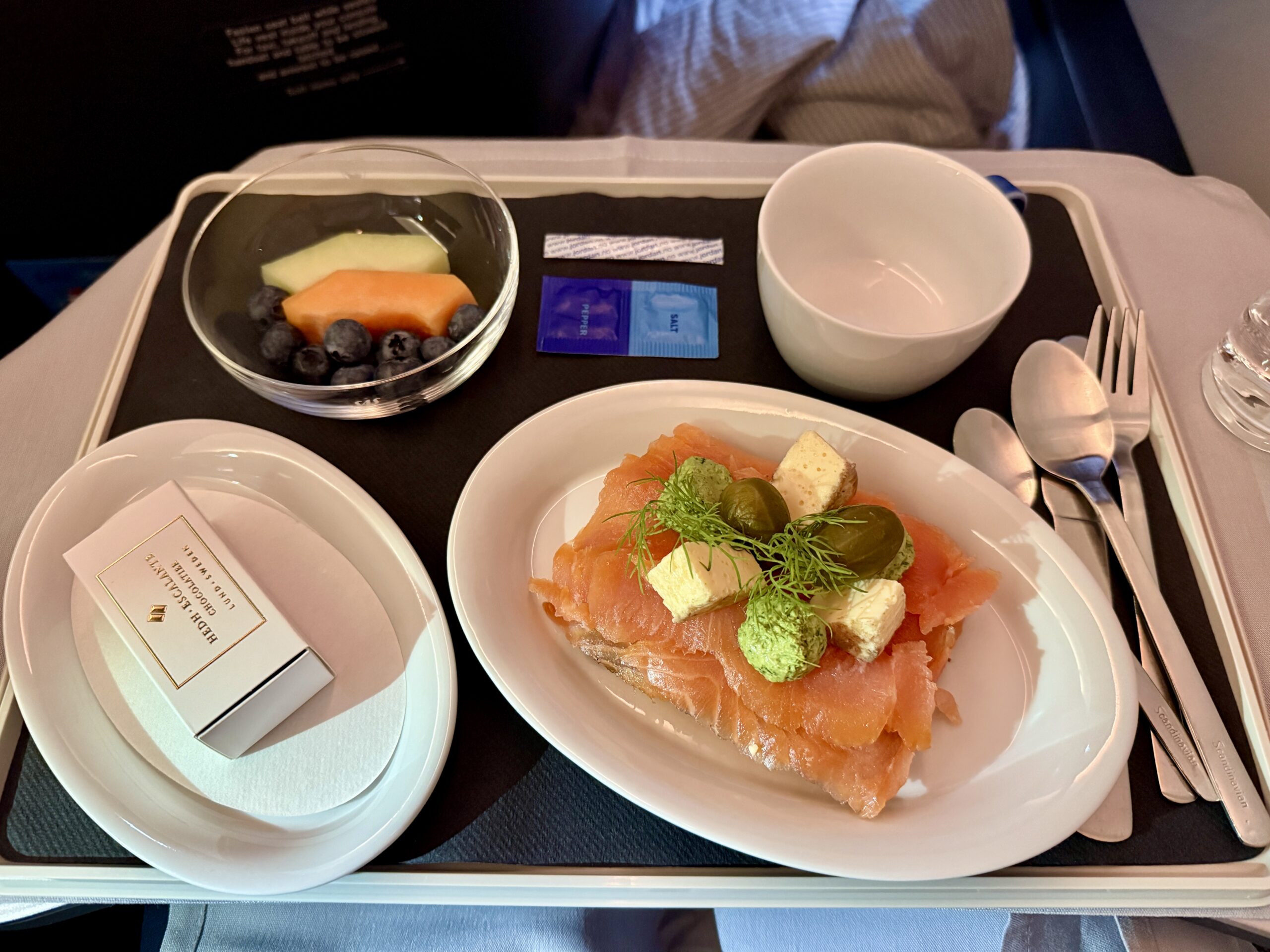 smoked salmon on a tray with fruit and box of chocolates