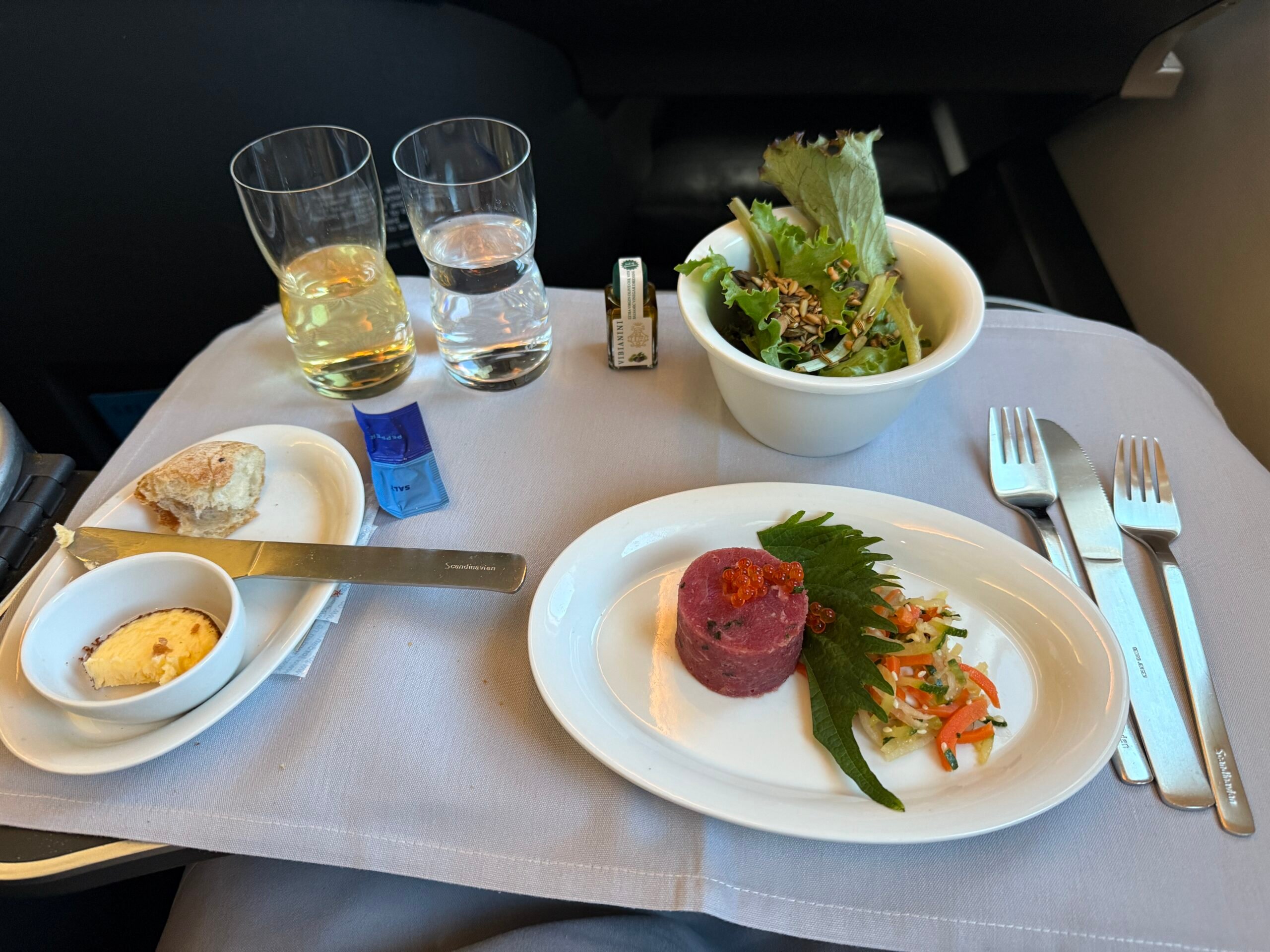 several plates and glasses on a plane tray table