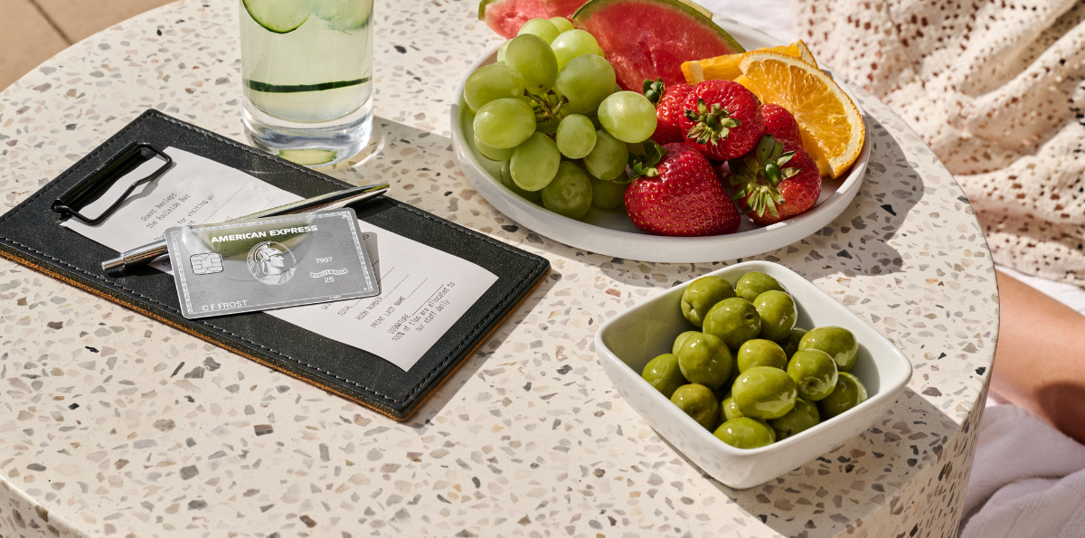 Amex Platinum Mirror Card Design on restaurant table with food and drink.