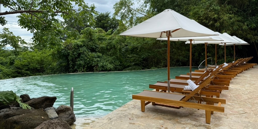 Andaz Peninsula Papagayo Pool with lounge chairs and umbrellas