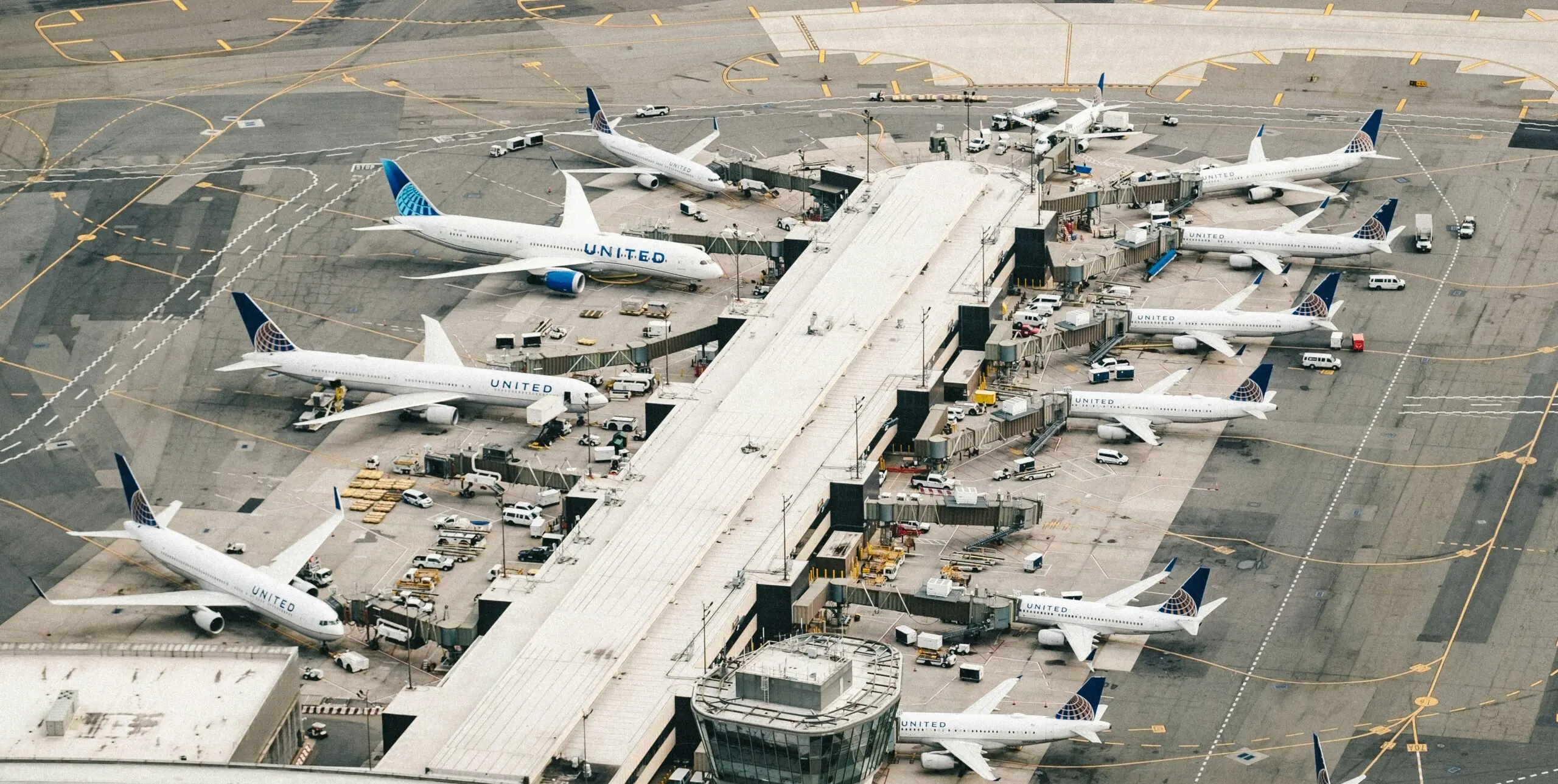 several united planes parked at gates